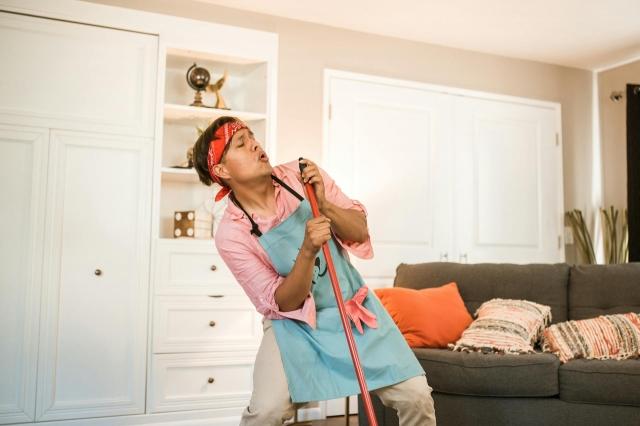 https://www.pexels.com/photo/man-pretending-singing-with-a-broom-5591835/