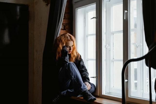 Photo by MART  PRODUCTION: https://www.pexels.com/photo/woman-in-black-leather-jacket-sitting-on-brown-wooden-floor-7277896/