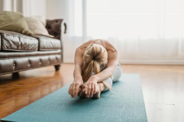 A woman doing yoga in her living room.
